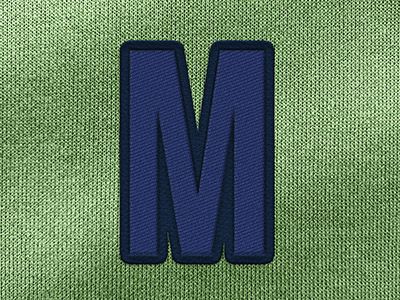 letter M geweven op groene textiel